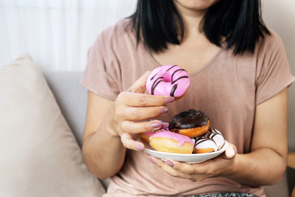 Woman Hand Eating Donuts , Sugar Addiction Concept , Unhealthy E